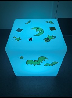 Photo shows the 3D cube lightbox with stars, moons, and bat stickers affixed to all faces.