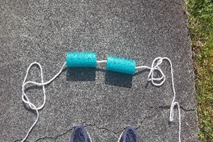 Two segments of pool noodle with a rope threaded through