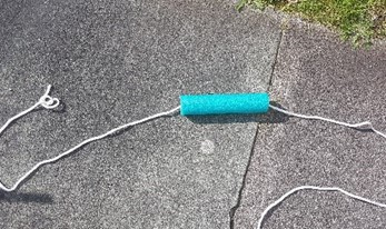 A segment of pool noodle with a rope threaded through