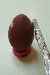 Football set on a tee with a bat covered in tin foil