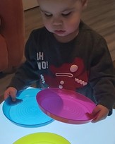 Child examines transparent trays on a lightbox